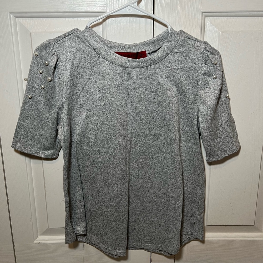 Blouse with pearls on shoulders.